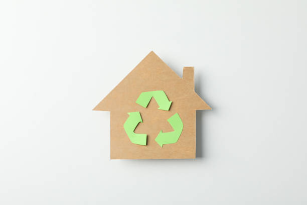 istock Cardboard house with recycling sign on white background, space for text 1204435339