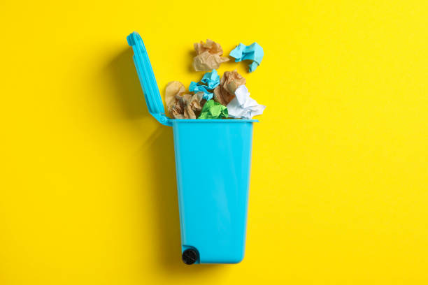 istock Recycle bin with trash on yellow background, space for text 1204435399
