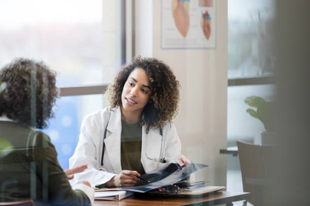 istock Doctor reviewing x-ray with patient 1204436145