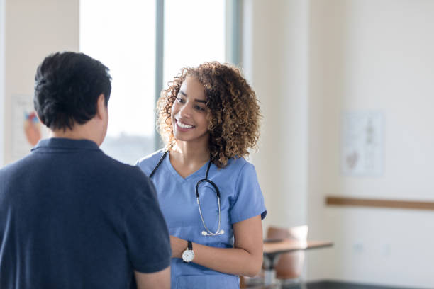 istock Caring nurse talks with senior male patient 1204436206