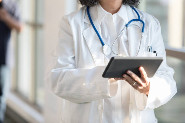 istock Unrecognizable female doctor uses a digital tablet 1204436208
