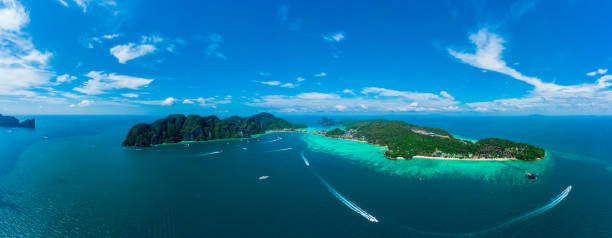 istock Panorama of tropical islands Phi Phi Don and Phi Phi Leh in sea. Vacation holidays concept background. Aerial view of Tonsai bay with many boats and speedboats above coral reef.  Krabi, Thailand 1204436265