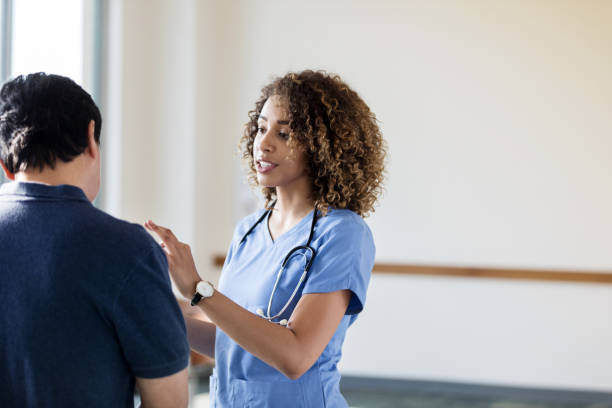 istock Unrecognizable man listens as female nurse speaks 1204436274