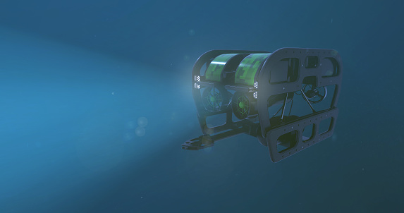 A deep sea ROV - remote operated vehicle, with it's lights penetrating the darkness of the bottom of the ocean