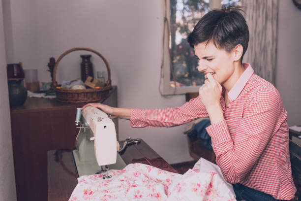 女性は縫製機で指を縫い、刺す。 - finger in mouth ストックフォトと画像