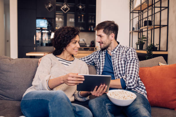 istock Couple spending the evening on the sofa, watching something on tablet 1204439605