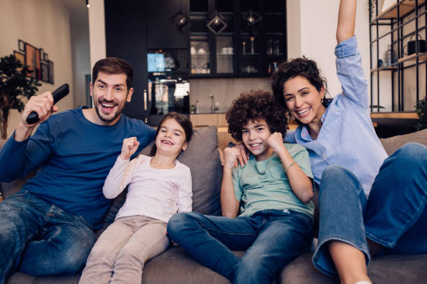 istock Kids watching TV with their parents and having fun 1204439621