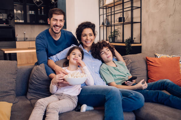 istock Happy family watching shows on TV and snacking popcorn 1204439636