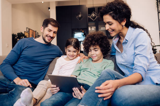 istock Happy family watching cartoons on digital tablet 1204439677