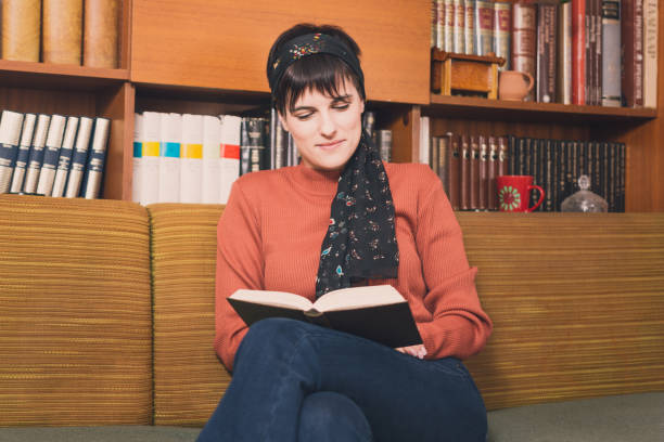 istock Beautiful woman reading a book at home. 1204441273