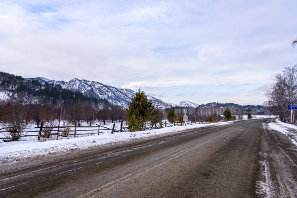 A road that goes off into the distance past snow-capped mountains