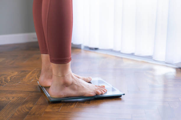 istock Young woman on home scales 1204442450
