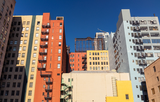 A group of buildings in Los Angeles, painted in a range of colors, against a deep blue sky.