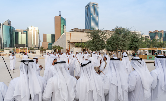 Emirati Men performing the Yowla, a traditional dance in the heritage of the United Arab Emirates in Downtown Abu Dhabi\n- Abu Dhabi, UAE, December 22, 2020