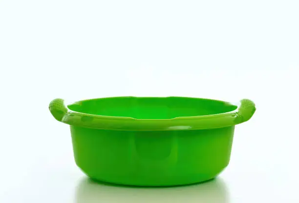 Cleaning wash bowl, plastic hand basin green color isolated against white background, Domestic household cleaning