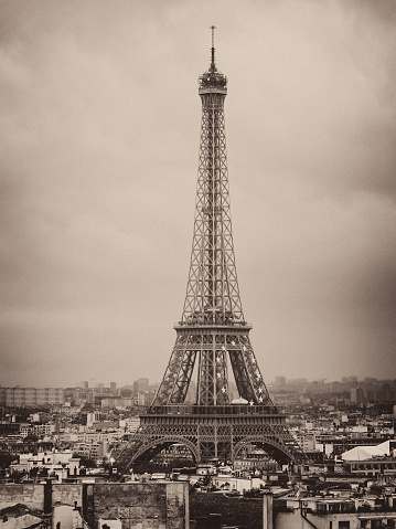 Facing the Eiffel Tower in Paris, under a cloudy sky