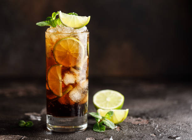 cuba libre con ron marrón, cola, menta y lima. cuba libre o cóctel de té helado de larga isla con bebidas fuertes - ron fotografías e imágenes de stock