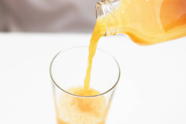 istock Orange juice is poured into a glass. Healthy breakfast. 1204451894