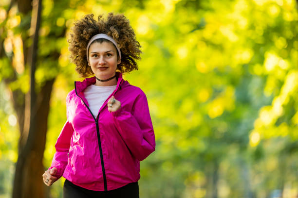 istock Young female athlete jogging in forest. Jogger doing morning physical training. 1204453434