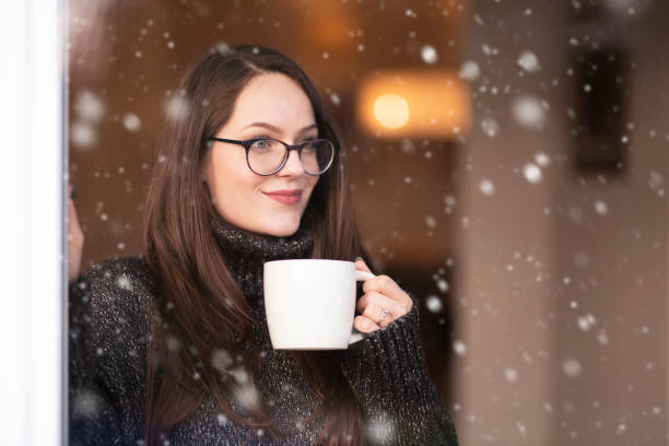istock Woman relaxing by the window and drinking tea 1204453583