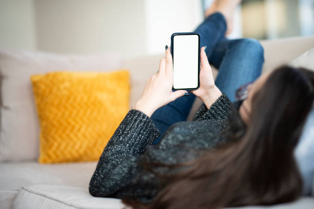 istock Woman with digital tablet in her hand relaxing on sofa at home 1204453651