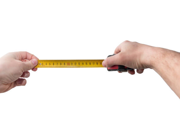 istock Measuring tape, yellow, in a male hand 1204454818