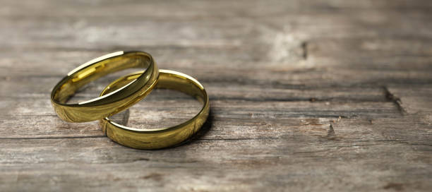 istock gold wedding rings on wooden table soft focus macro shot 3d render illustration 1204455725