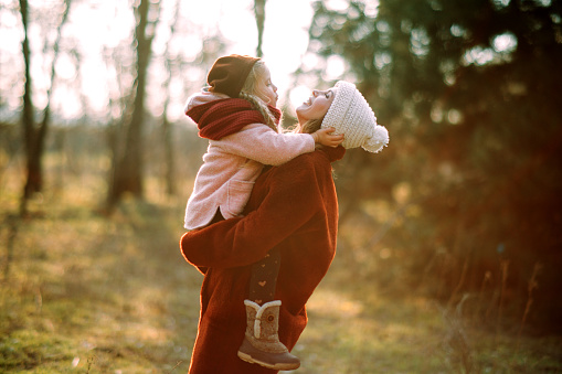 Mother and daughter have fun and laugh in the forest.