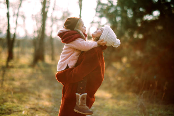 mãe e filha se divertem e riem na floresta. - family child mother autumn - fotografias e filmes do acervo