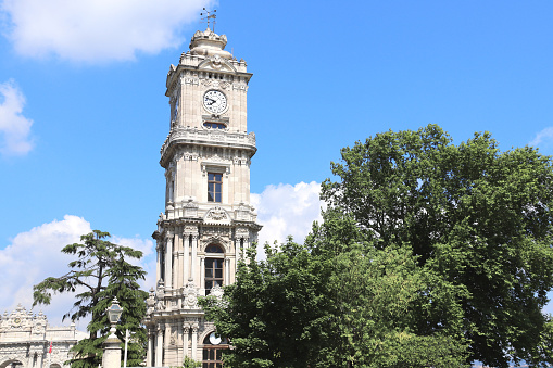Clock tower (Saat kulesi) in park of Dolmabahce Palace (Dolmabahce Sarayi), Istanbul, Turkey