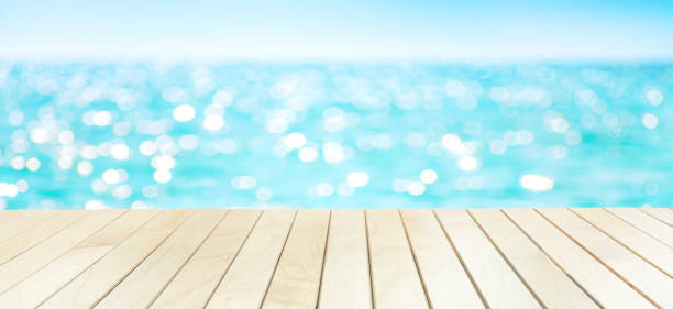 istock The blur sea and sky background with wood deck or table on the beach. 1204459303