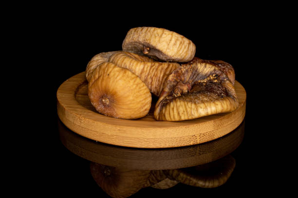 istock Dried fig fruit isolated on black glass 1204459450
