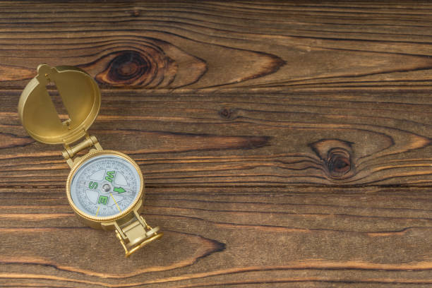istock Golden old compass on a wooden table background. 1204460671