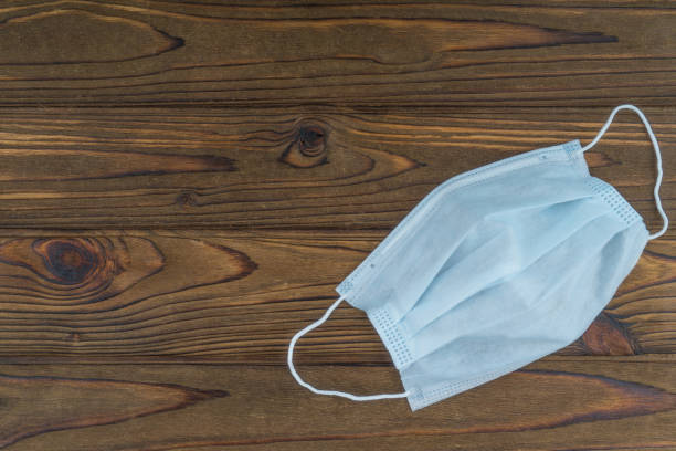 istock Protective medical mask on a wooden background. Coronavirus 1204460698