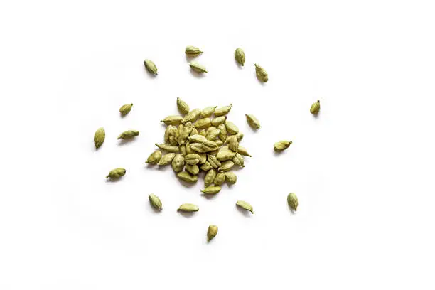 Top view of a pile of organic dry cardamom seeds isolated on a white background