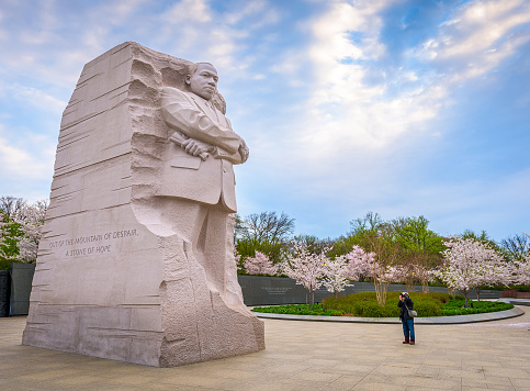 Washington DC, USA - April 12, 2015: A man photographs the Martin Luther King Jr. Memorial during spring season in West Potomac Park. The work was created by Lei Yixin and opened to the public August 22, 2011.