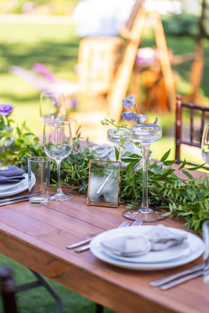 istock Preparing for an open-air party. Decorated with fresh flowers served tables. Table number. Decoration Details 1204464451