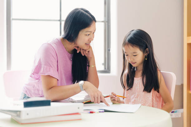 istock Mother is helping daughter with homework. 1204464807