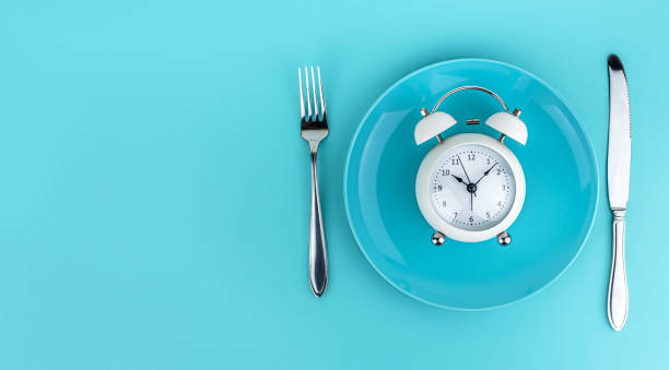 istock Alarm clock with fork and knife on the table. Time to eat, Breakfast, Lunch Time and Dinner concept 1204465479
