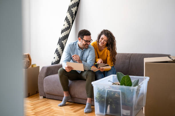 istock Smiling couple choosing paint colors from chart 1204466570