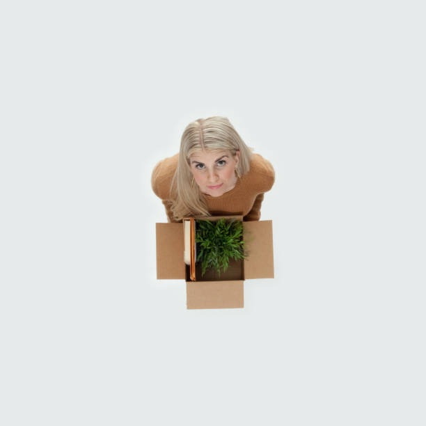 istock Caucasian female standing wearing sweater and holding box 1204466582