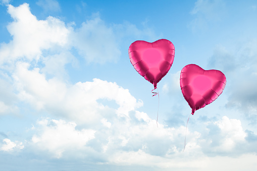 Two Red balloons on Blue sky clouds background. Beautiful landscape with clouds on sky