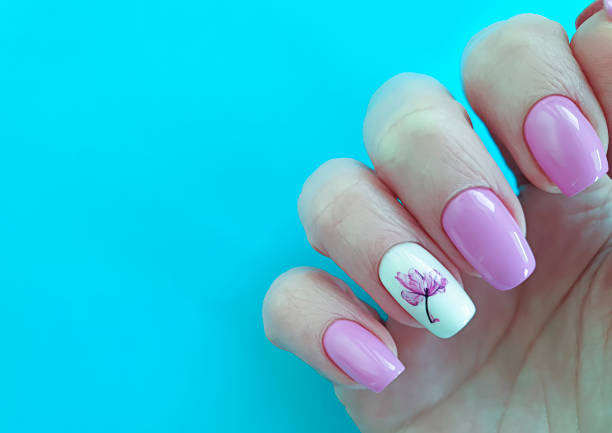 istock female hand nail beautiful manicure on a colored background, banner 1204467441
