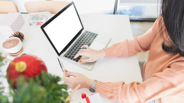 asian young woman using laptop computer and holding credit card for christmas online shopping stock photo