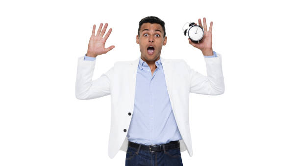 istock African ethnicity young male standing wearing button down shirt and holding clock 1204469487