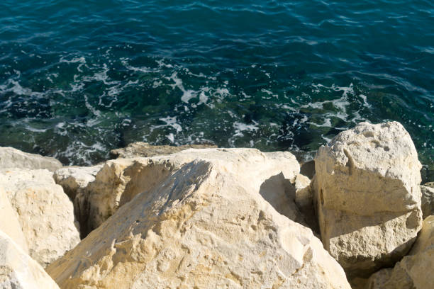 istock White rocky cliff and blue sea below 1204469631