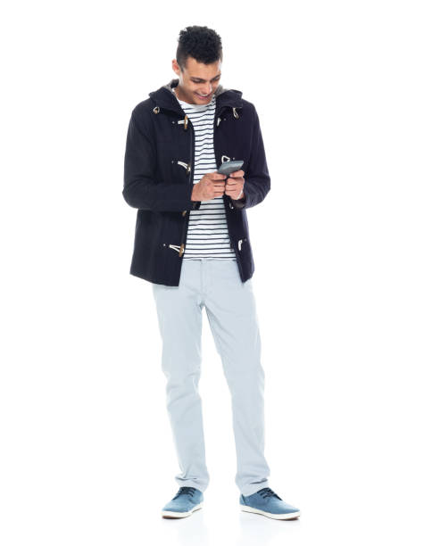 istock African ethnicity male standing wearing jacket and using smart phone 1204469903