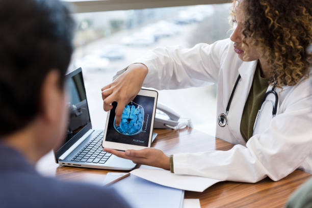 medico donna spiega scansione cerebrale a paziente maschio irriconoscibile - doctor radiologist computer latin american and hispanic ethnicity foto e immagini stock