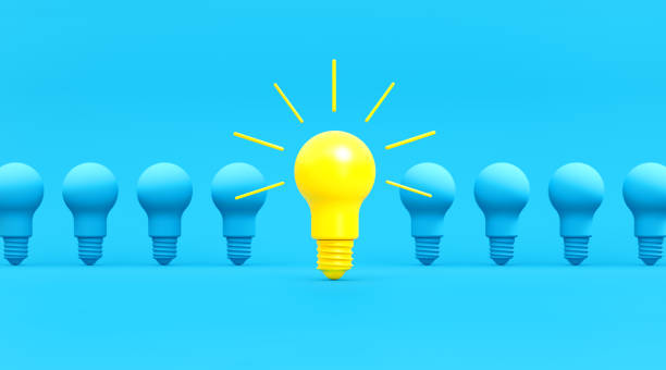 istock Blue and Yellow Light Bulbs in a Row over Turquoise Background 1204472701