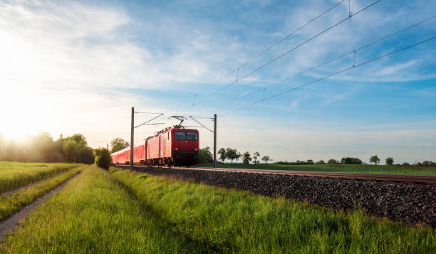 istock Red train traveling in a summer landscape. Train in nature 1204472841